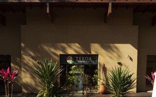 Una entrada de edificio con un letrero que dice "TEKOA Lodge de Selva".