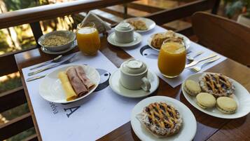 Una mesa de desayuno con platos de comida, una taza de café y un vaso de jugo de naranja.