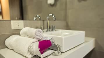 Une salle de bain avec un lavabo blanc, deux robinets et un sèche-serviettes.