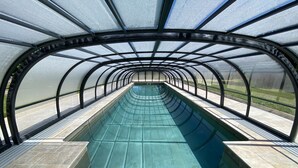 Ein überdachter Pool mit einer gewölbten Dachkonstruktion.