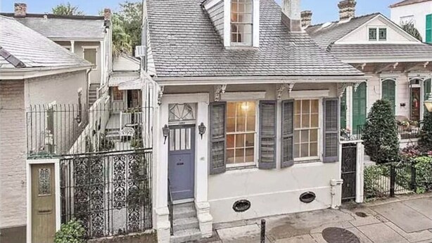 A two-story house with a gabled roof, a front porch, and a small front yard.