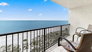 A balcony with a view of the sea, wicker furniture, and a tiled floor. - OCEANFRONT condo directly overlooking the clear blue water of the Gulf of Mexico (Madeira Beach)
