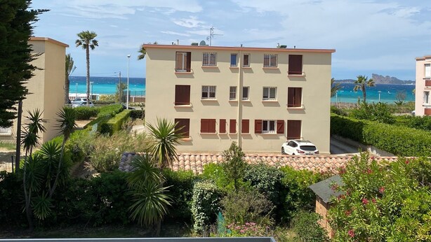 A multi-story residential building with a balcony, surrounded by greenery and a view of the sea. - Le Cosy Beach (Saint-Cyr-sur-Mer)