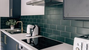 Una cocina moderna con estufa integrada, cafetera y tostadora.