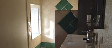 A bathroom with a toilet, sink, and mirror.