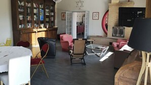 Un salón amplio con un aparador de madera, una mesa de centro de vidrio y una chimenea.