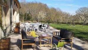 Un patio al aire libre con mobiliario y vistas a árboles.