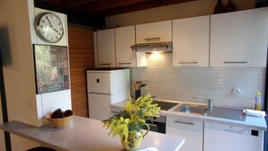 A modern kitchen with white cabinets, a built-in oven, a sink, and a clock on the wall. - Beautiful 67 m² duplex with garden.golf view (Moliets-et-Maa)