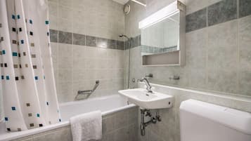 A bathroom with a bathtub, a sink, a toilet, and a shower curtain.