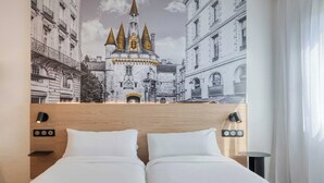 A hotel room with a bed, a headboard with a wooden finish, a wall-mounted light, and a mural of a castle. - B&B Hotel Bordeaux Mérignac Cadera Aéroport (Merignac)