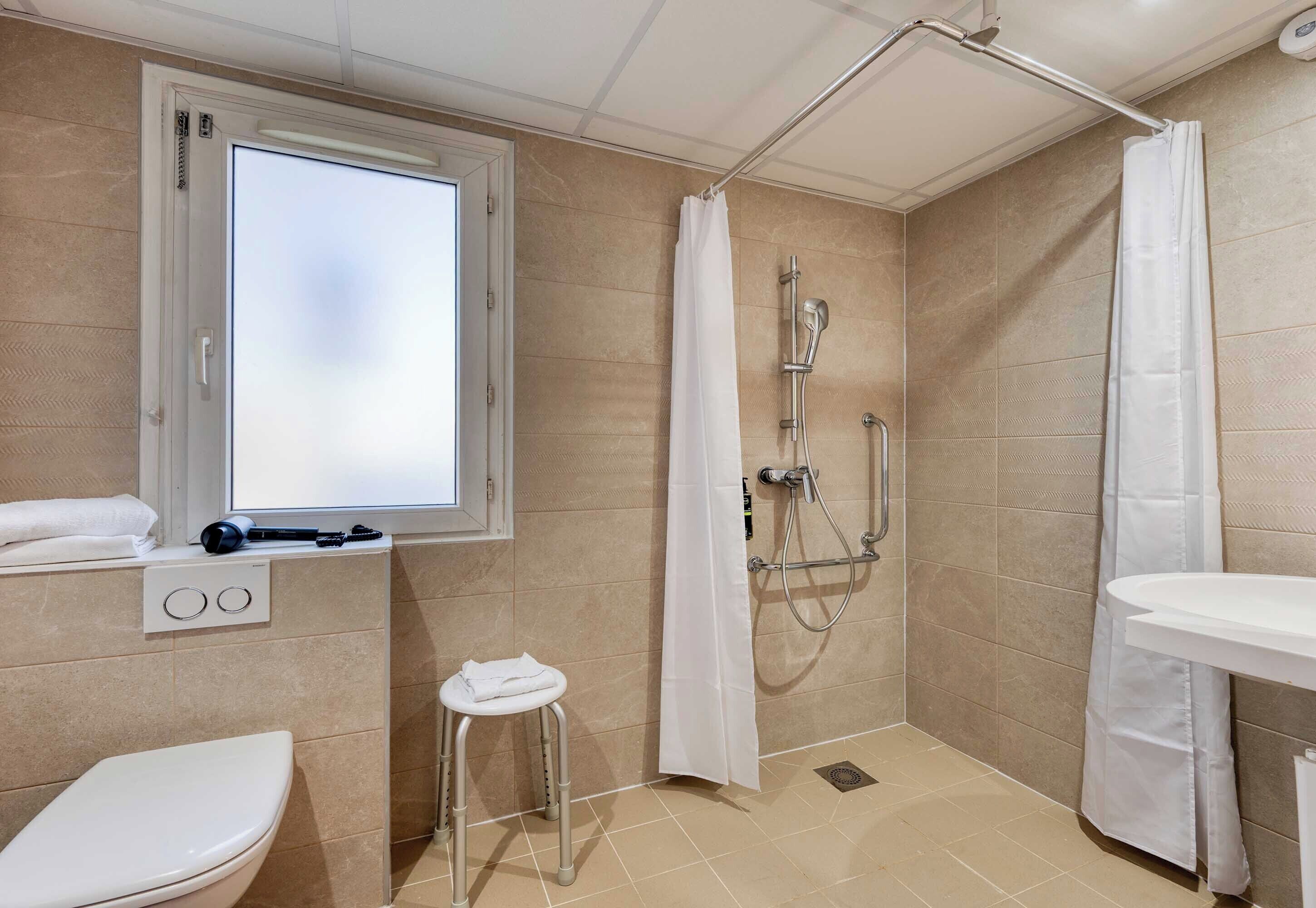 Standaard tweepersoonskamer, toegankelijk voor rolstoelgebruikers, niet-roken | Badkamer | Een douche, handdoeken, zeep, toiletpapier