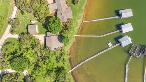 Een overzicht vanuit de lucht van een woongebied met huizen, een steiger en een brug over het water.