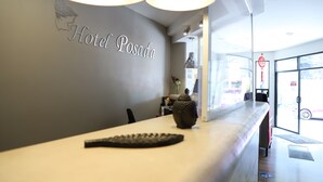 Ein Empfangsschalter mit einem Schild, auf dem 'Hotel Posada' steht, und einer dekorativen Vase.