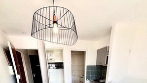 A modern apartment with a dining area, kitchenette, and a living room with a sofa.