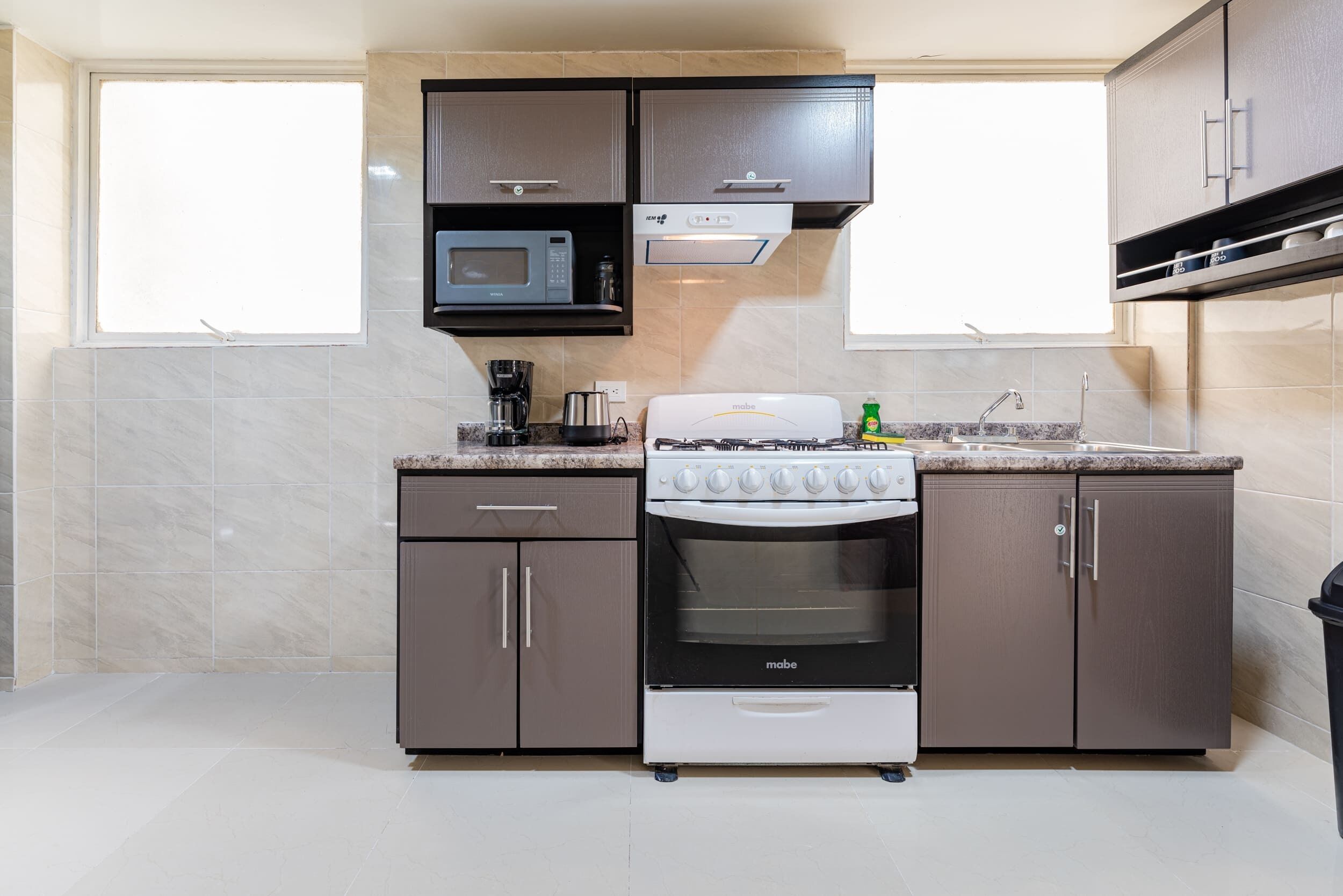 A kitchen with a stove, microwave, and cabinets.
