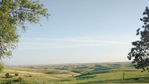 Un paisaje con colinas onduladas y cielo despejado.