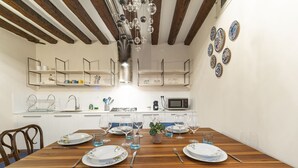 A dining area with a wooden table set for six, surrounded by blue chairs. - SAN SILVESTRO HOUSE VENICE (Venezia)