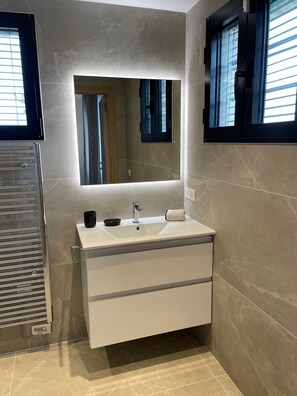 Enjoy a refreshing bathroom experience with a large mirror, light, and a convenient vanity with a single drawer.