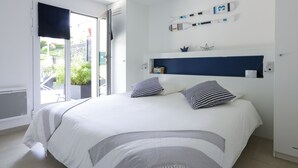Une chambre à coucher avec un lit, une fenêtre et une étagère fixée au mur, sur laquelle sont posés divers objets.