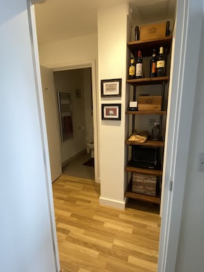 Enter a cozy space with a door to your right and a shelf displaying personal touches.