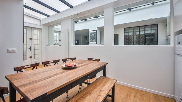 A modern dining area with a wooden table, benches, and a skylight above. - 2.Luxueux Duplex#3Bedrooms#FullEquipped#République (Paris)