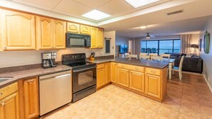 A modern kitchen with wooden cabinets, stainless steel appliances, and a large island. - 779 Amelia by the Sea, Amelia by the Sea 3 Bedroom! Fishing Pier! Oceanfront! (Fernandina Beach)