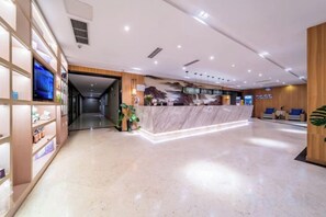 A hotel reception area with a marble counter, wooden shelving, and a clear view of the hallway. - Seaman Hotel (Chongqing Jiazhou Hongqi Hegou Light Rail Station) (Chongqing)