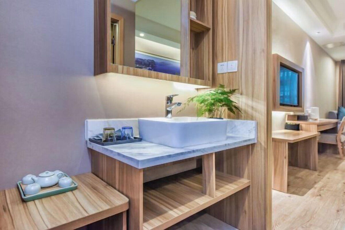 A modern bathroom with a wooden vanity, a sink, and a mirror.
