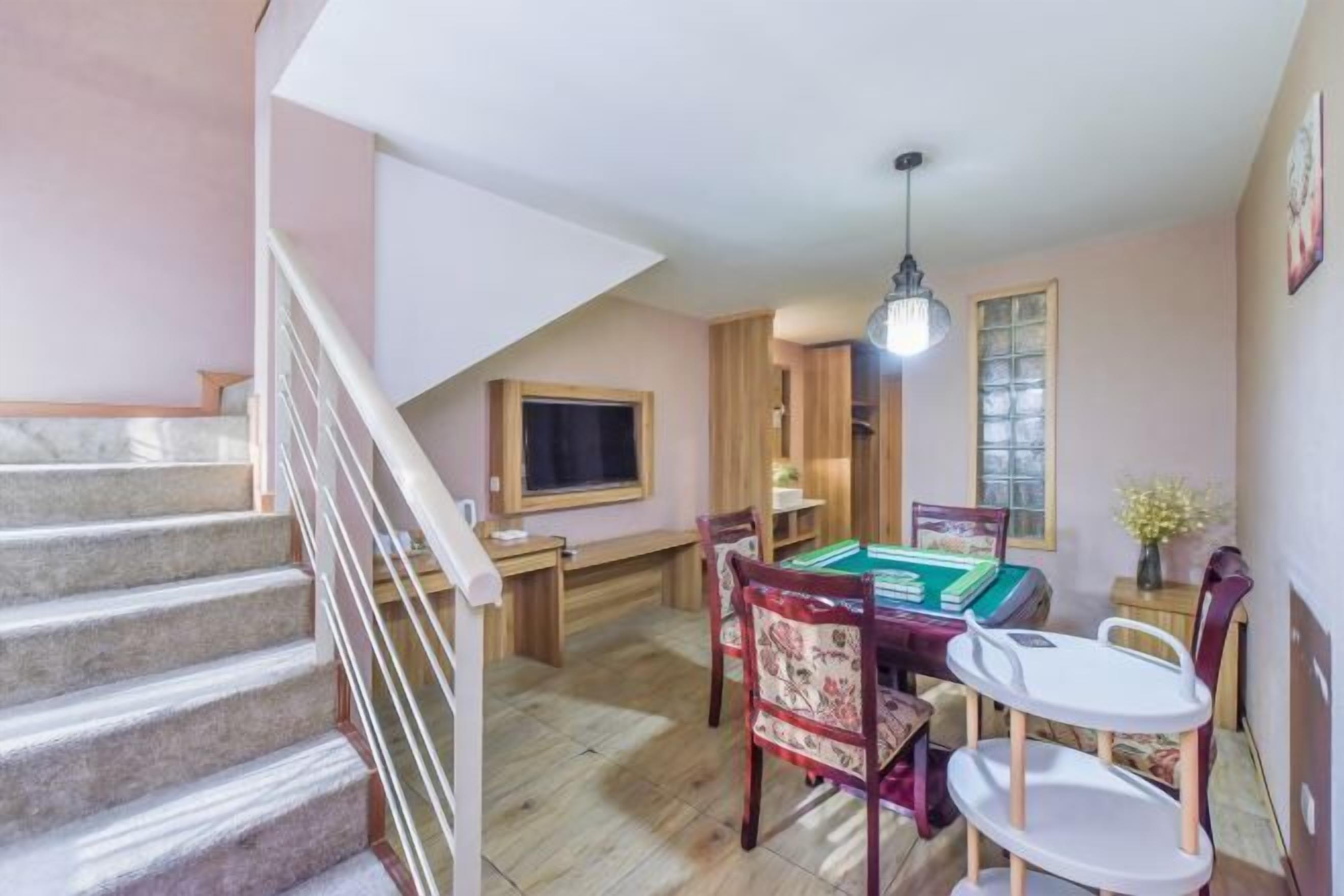 Un comedor con mesa de billar, sillas de madera y una mesita con una silla.