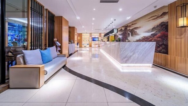 A modern hotel lobby with a reception desk, seating area, and a large mural. - Seaman Hotel (Chongqing Jiazhou Hongqi Hegou Light Rail Station) (Chongqing)