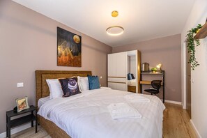Un dormitorio con cama, mesita de noche y un cuadro en la pared.