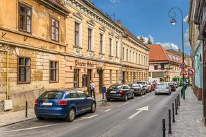 Una calle con coches estacionados y un edificio con un letrero que dice 'Poarta Schi'.