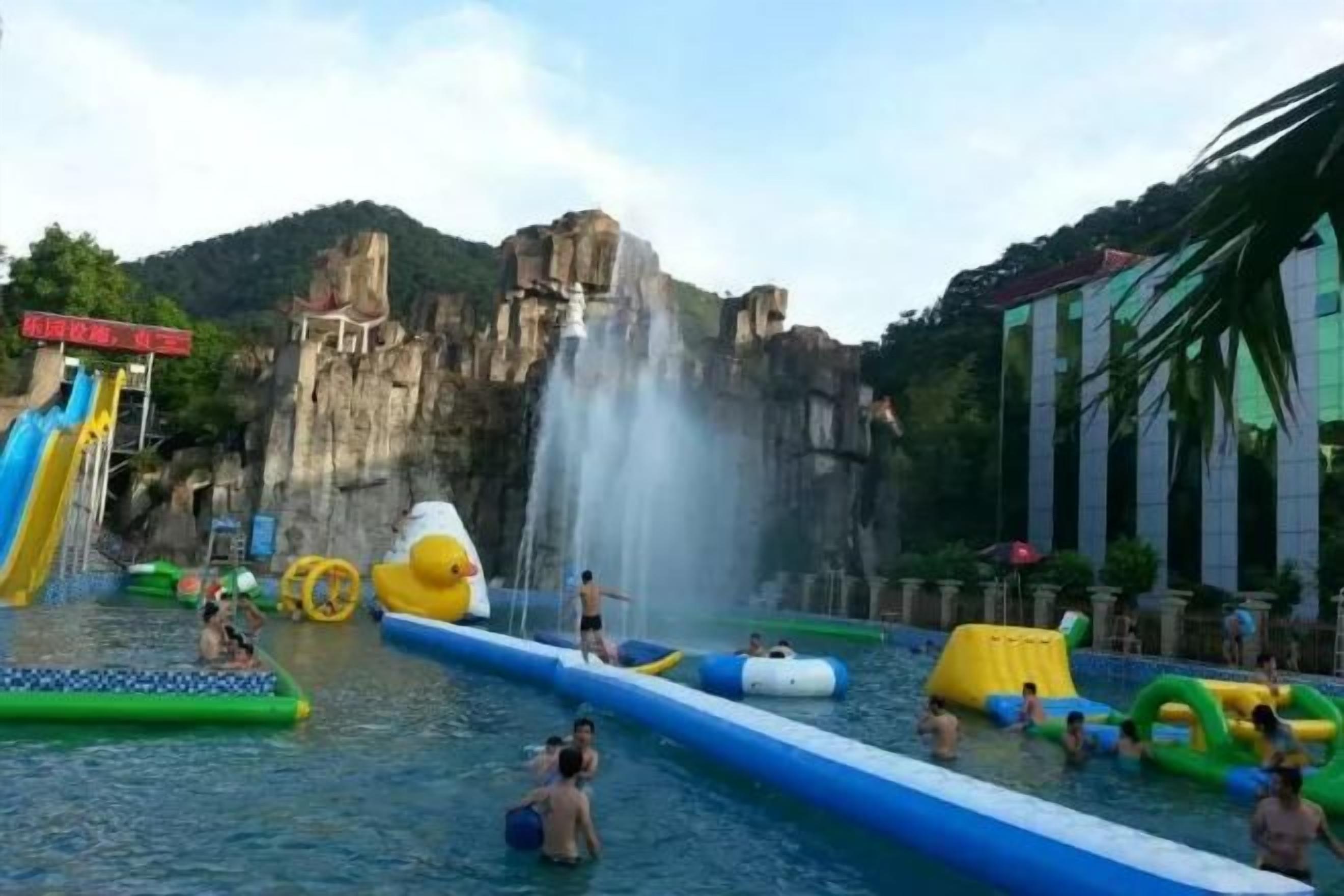 A water park with slides, a large water slide, and people enjoying the facilities.