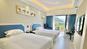 A hotel room with two beds, a desk, a chair, and a balcony with a view of greenery. - Zhenshan Hotel Resort (Zhaoqing Sihui Zhenshan Tourism Resort Area) (Sihui)