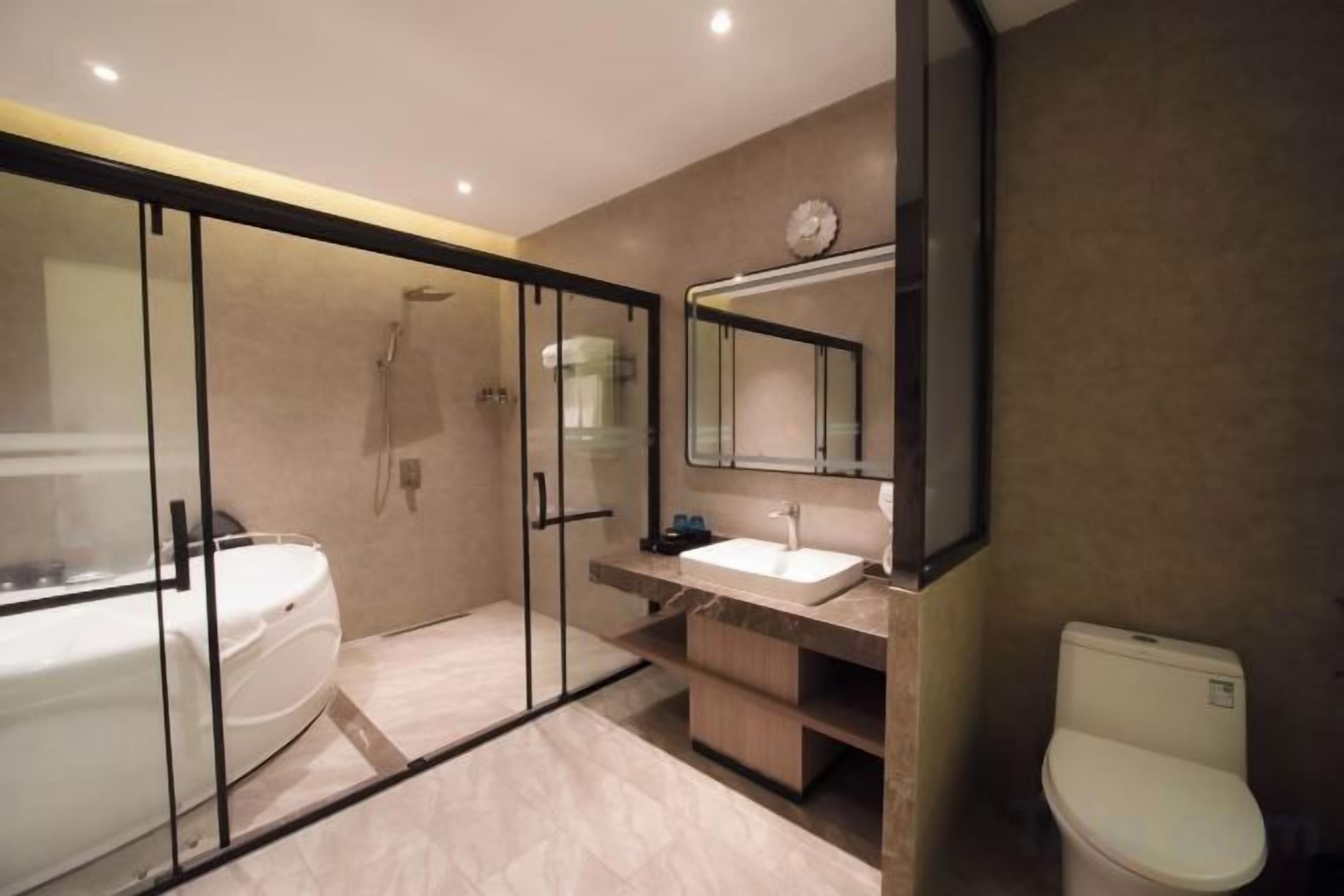 Une salle de bain moderne avec une douche à parois de verre, des toilettes séparées et un meuble-lavabo avec un miroir.