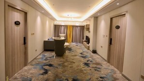 A hotel hallway with a patterned carpet, a seating area with a sofa and chairs, and doors numbered 01 and 02. - Zhenshan Hotel Resort (Zhaoqing Sihui Zhenshan Tourism Resort Area) (Sihui)