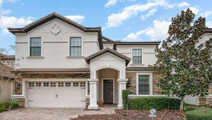 A two-story house with a garage, a front porch, and a well-maintained lawn. - Upscale Family Home w/ Custom Arcade, Theatre (Davenport)