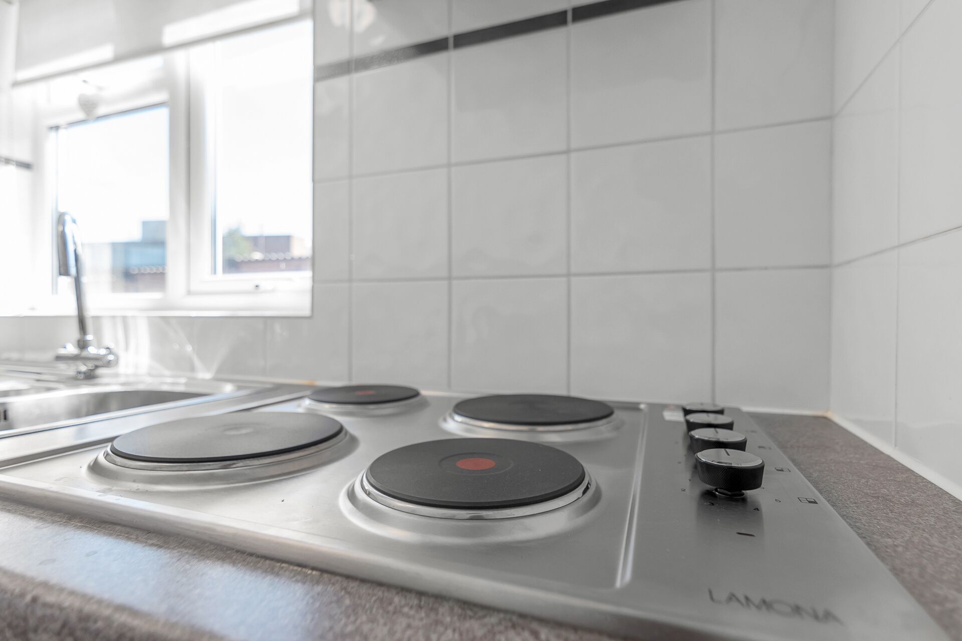 Una cocina con estufa a gas, un lavabo y una ventana.