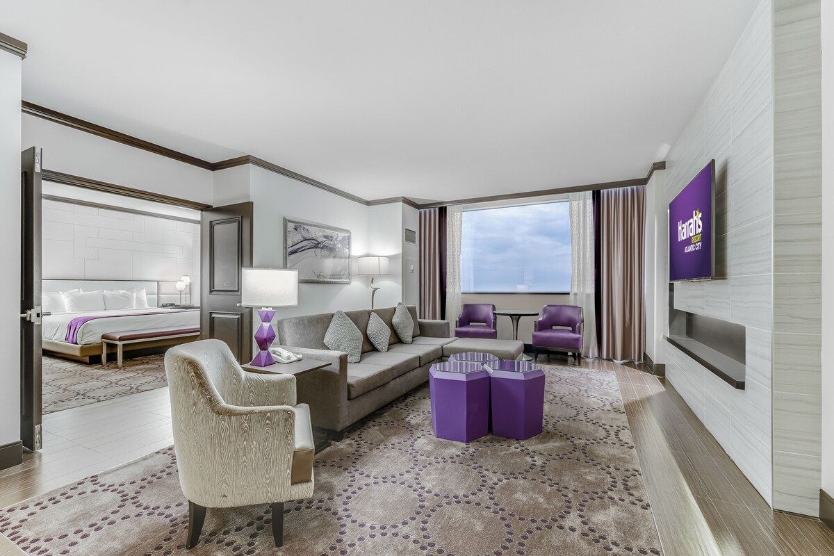 Una habitación de hotel moderna con cama, zona de estar y televisión.