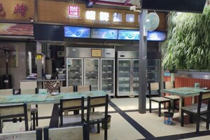 Een restaurant met binnenzitplaatsen, een balie en een vitrine.