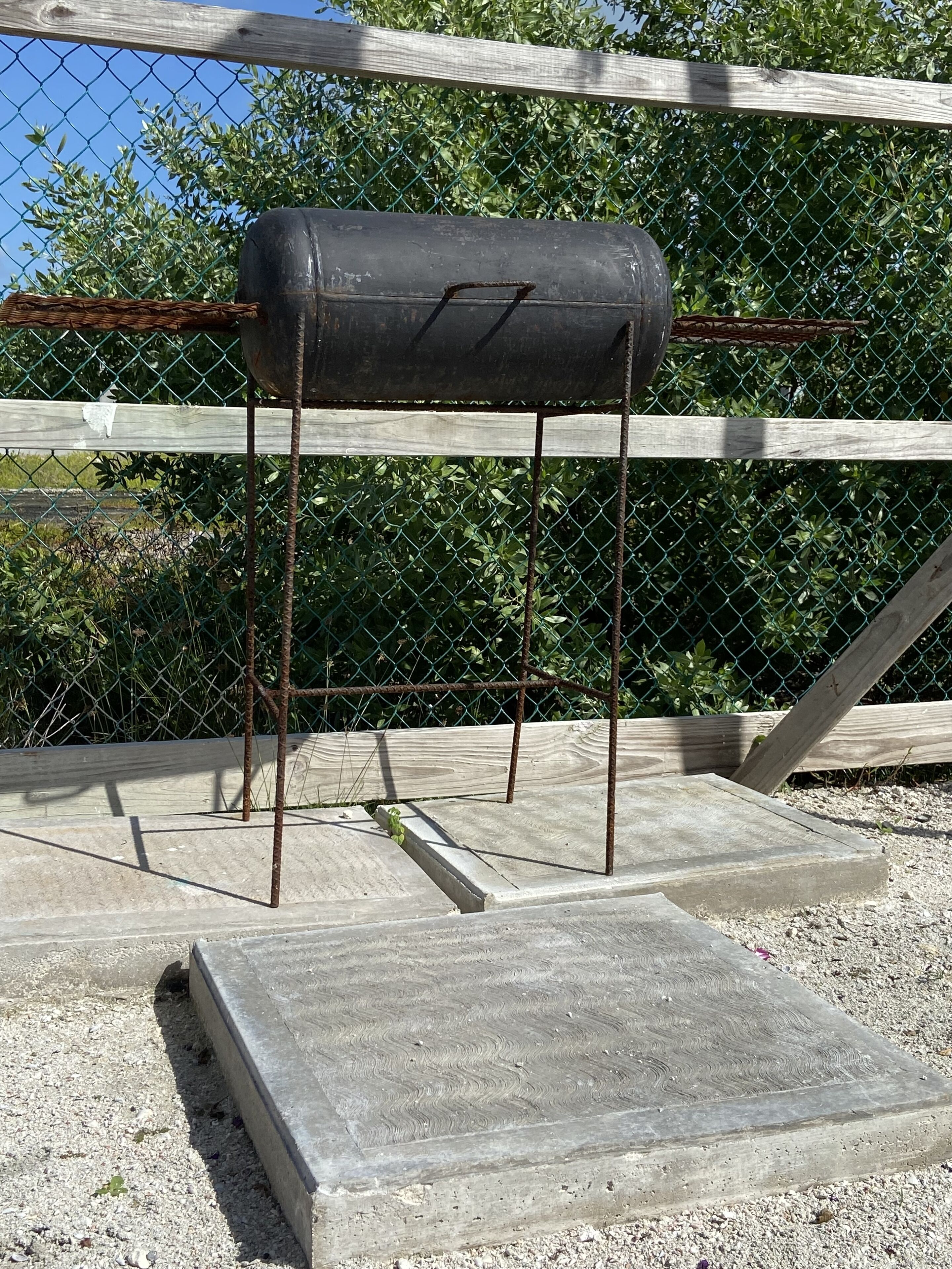 A concrete platform with a metal structure and a black object on top.