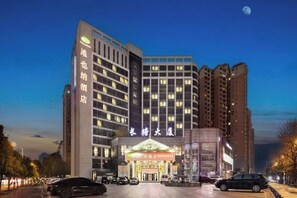 Un hotel de varios pisos con una entrada destacada y un gran letrero sobre las puertas.