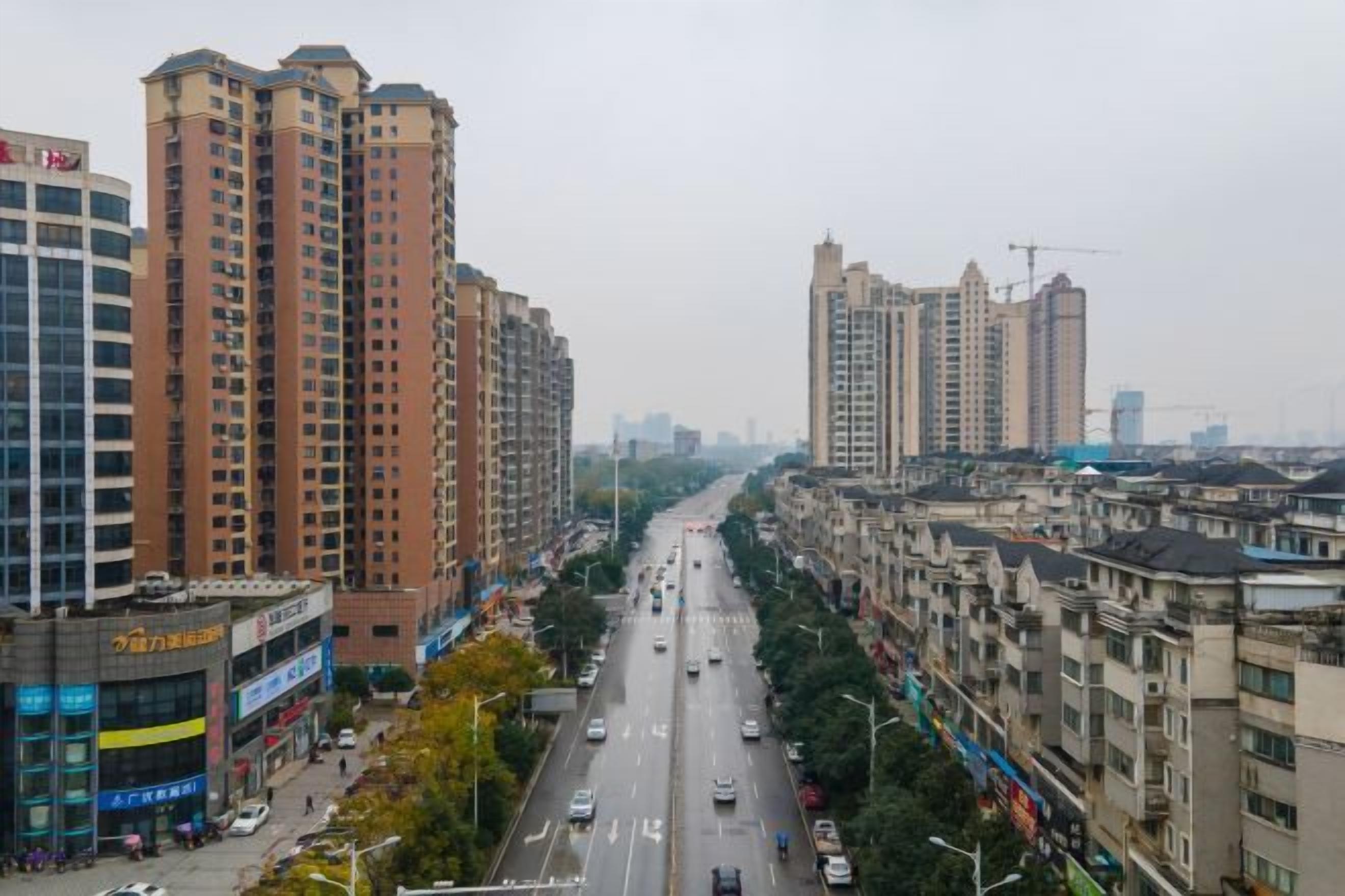Un paisaje urbano con rascacielos, una avenida de varios carriles y una acera.
