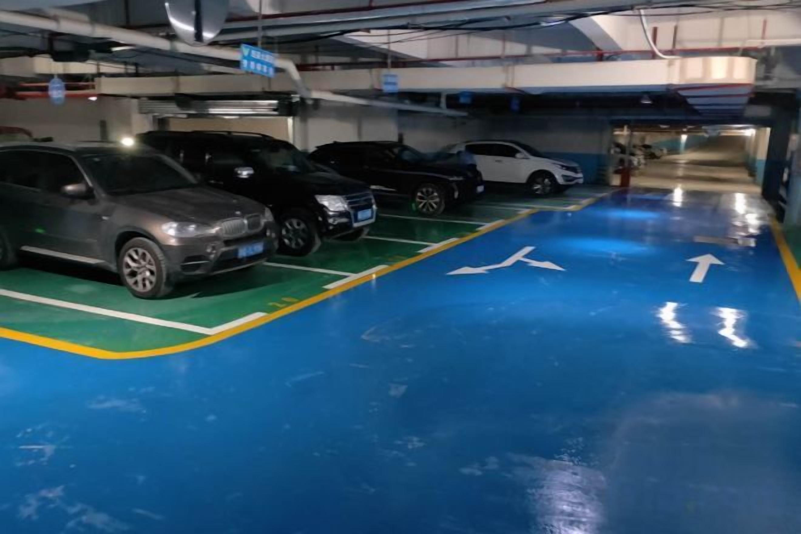 A parking garage with multiple cars parked in designated spaces.