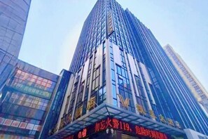 A tall, modern building with reflective glass windows and a prominent sign at the base. - Kailai Hotel (Yuqing)