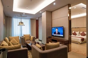 A hotel room with a TV, a sofa, a bed, and a desk. - Kailai Hotel (Yuqing)