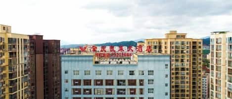 Un edificio de hotel de varios pisos con un letrero llamativo y varios balcones.