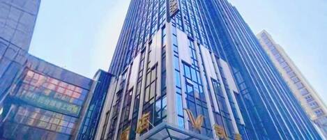 A tall, modern building with reflective glass facade and signage indicating a business or commercial use.