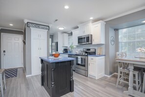 Enjoy cooking in this well-equipped kitchen with a central island, stainless steel appliances, and a dining area.