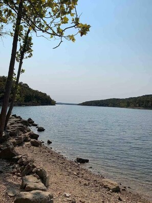 Escape to a serene lakeside haven surrounded by trees and open land.